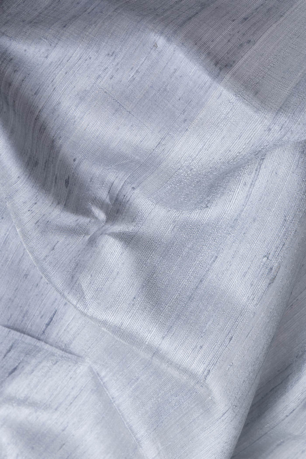 Close up of Grey Dual Tone Tussar Silk Saree with Plain Body and Zari Border.  displaying folds