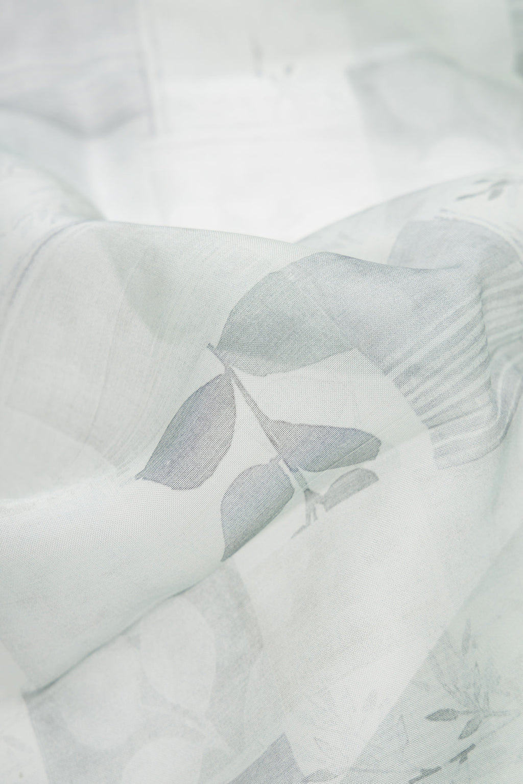 Close up of Grey Dual Tone Organza Silk Saree with Printed design on the body and Zari Border.  displaying folds