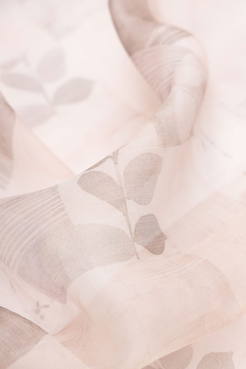 Close up of Rose Gold Dual Tone Organza Silk Saree with Printed design on the body and Printed Border.  displaying folds