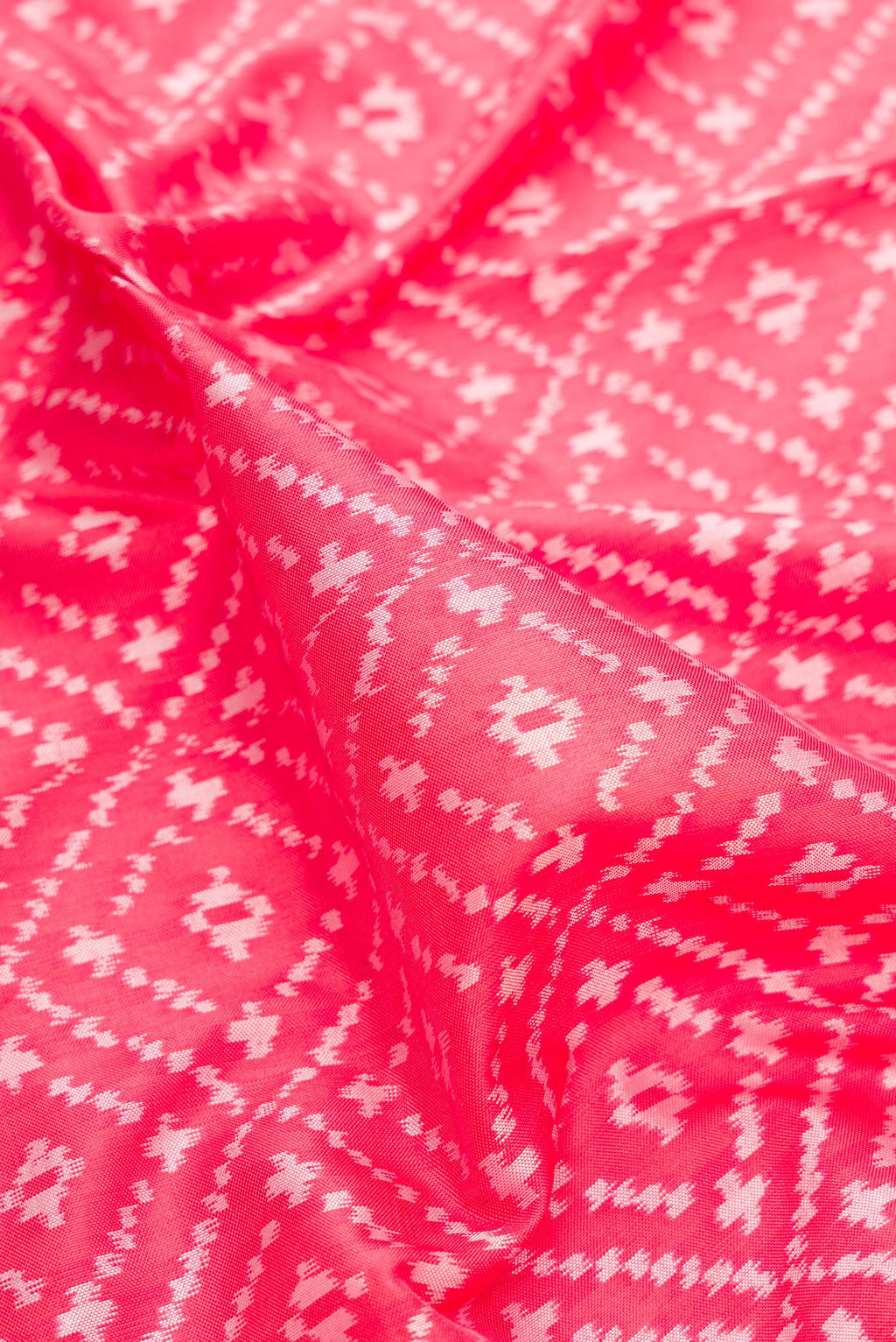 Close up of Pure Silk Coral Dual Tone Pochampally Saree with Ikat design on the body and Zari Border.  displaying folds