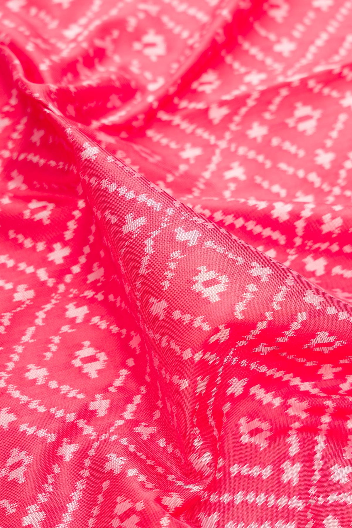 Close up of Pure Silk Coral Dual Tone Pochampally Saree with Ikat design on the body and Zari Border.  displaying folds