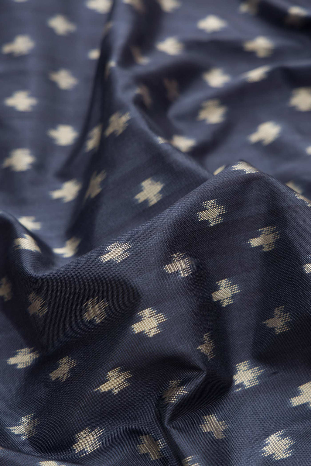 Close up of Navy Blue Dual Tone Double Ikat Saree with Ikat Print on the body and Zari Border.  displaying folds