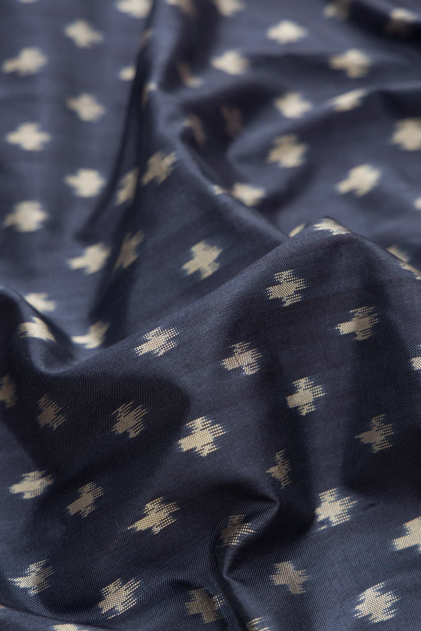 Close up of Navy Blue Dual Tone Double Ikat Saree with Ikat Print on the body and Zari Border.  displaying folds