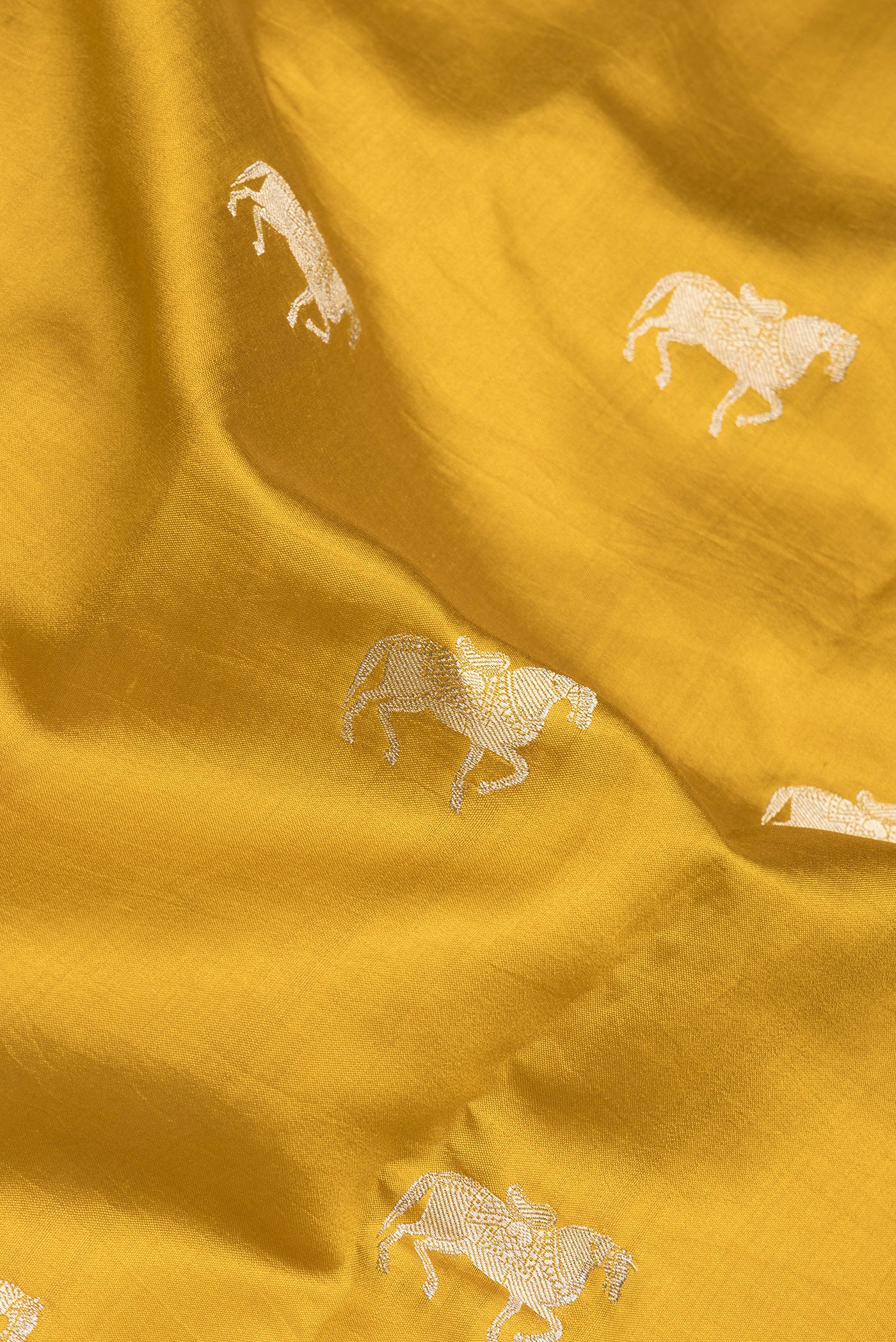 Close up of Mustard Tussar Silk Saree with Zari Butta on the body and Without Border.  displaying folds