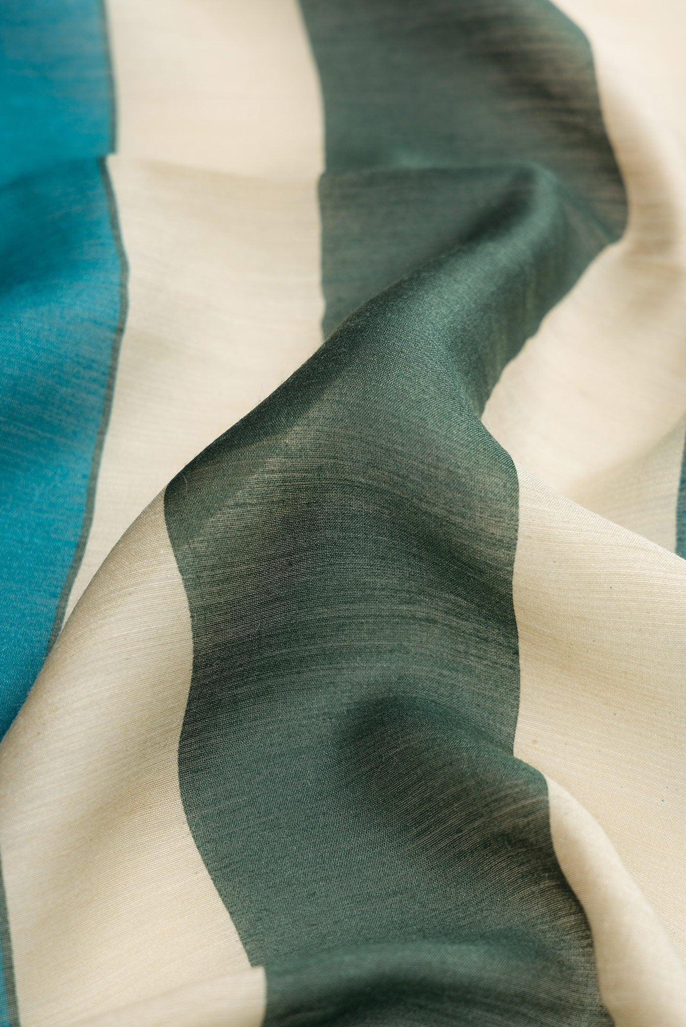 Close up of Peacock Blue Dual Tone Tussar Silk Saree with Embroidery on the body and Embroidery Border.  displaying folds