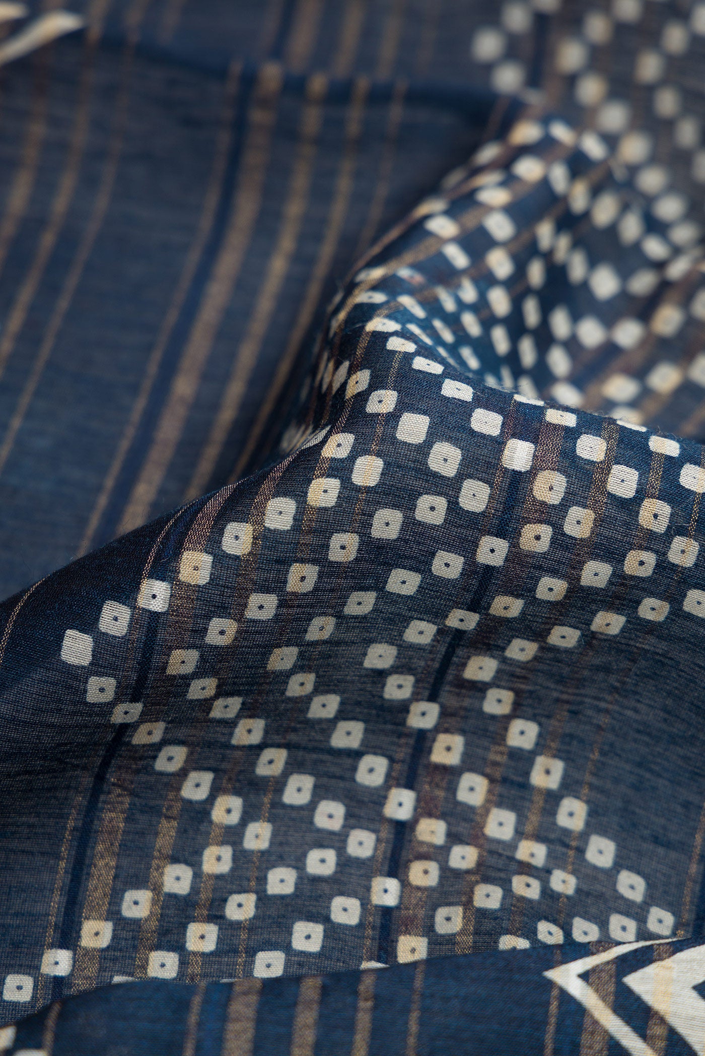 Close up of Navy Blue Dual Tone Tussar Silk Saree with Printed design on the body and Zari Border.  displaying folds