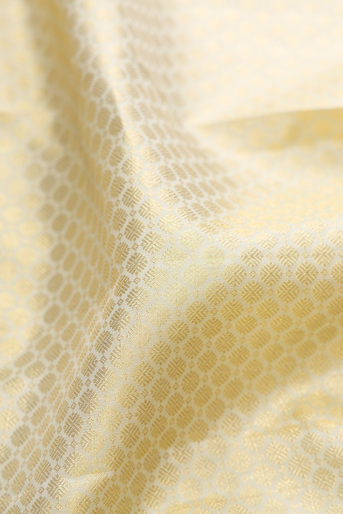 Close up of Cream Kanjivaram Silk Saree with Zari Brocade on the body and Zari Border.  displaying folds