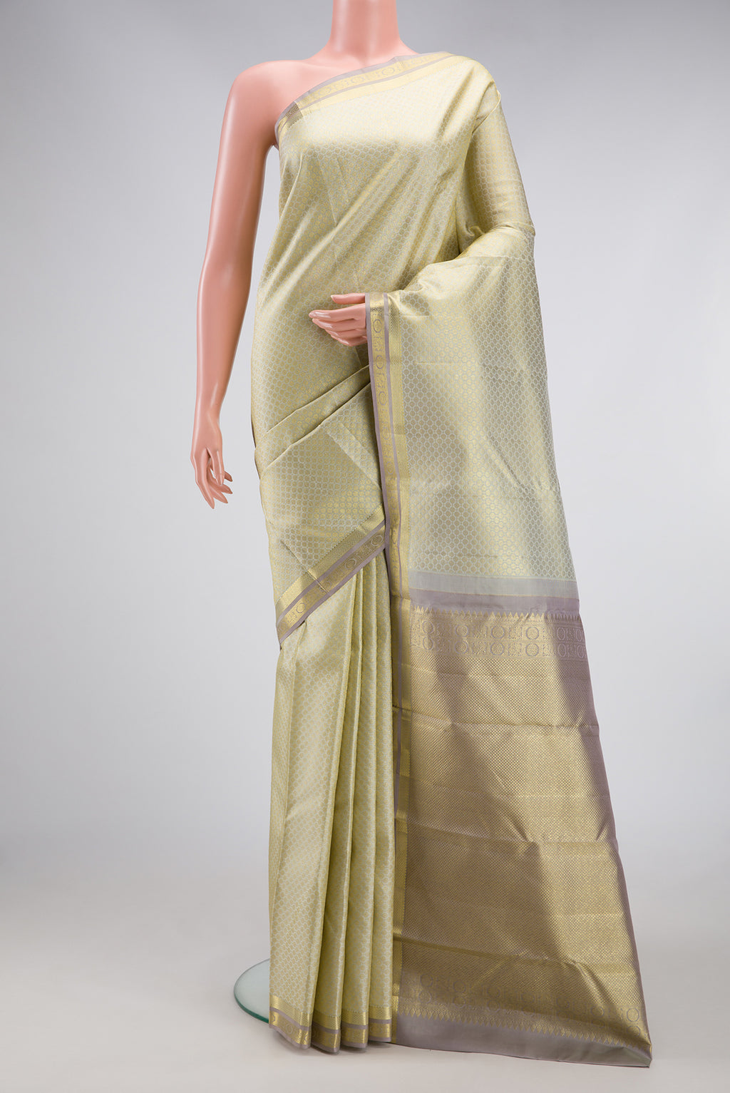 Cream Kanjivaram Silk Saree with Zari Brocade on the body and Zari Border.  displayed on a mannequin