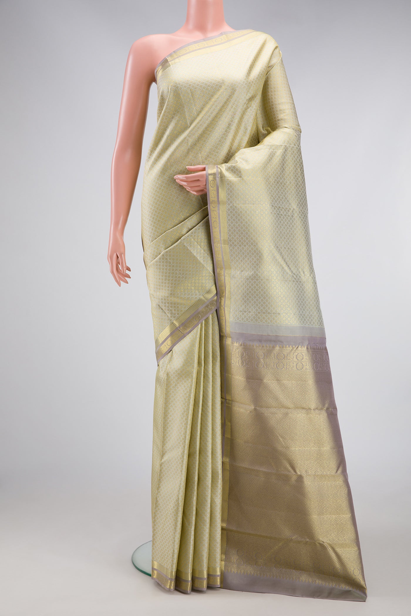 Cream Kanjivaram Silk Saree with Zari Brocade on the body and Zari Border.  displayed on a mannequin