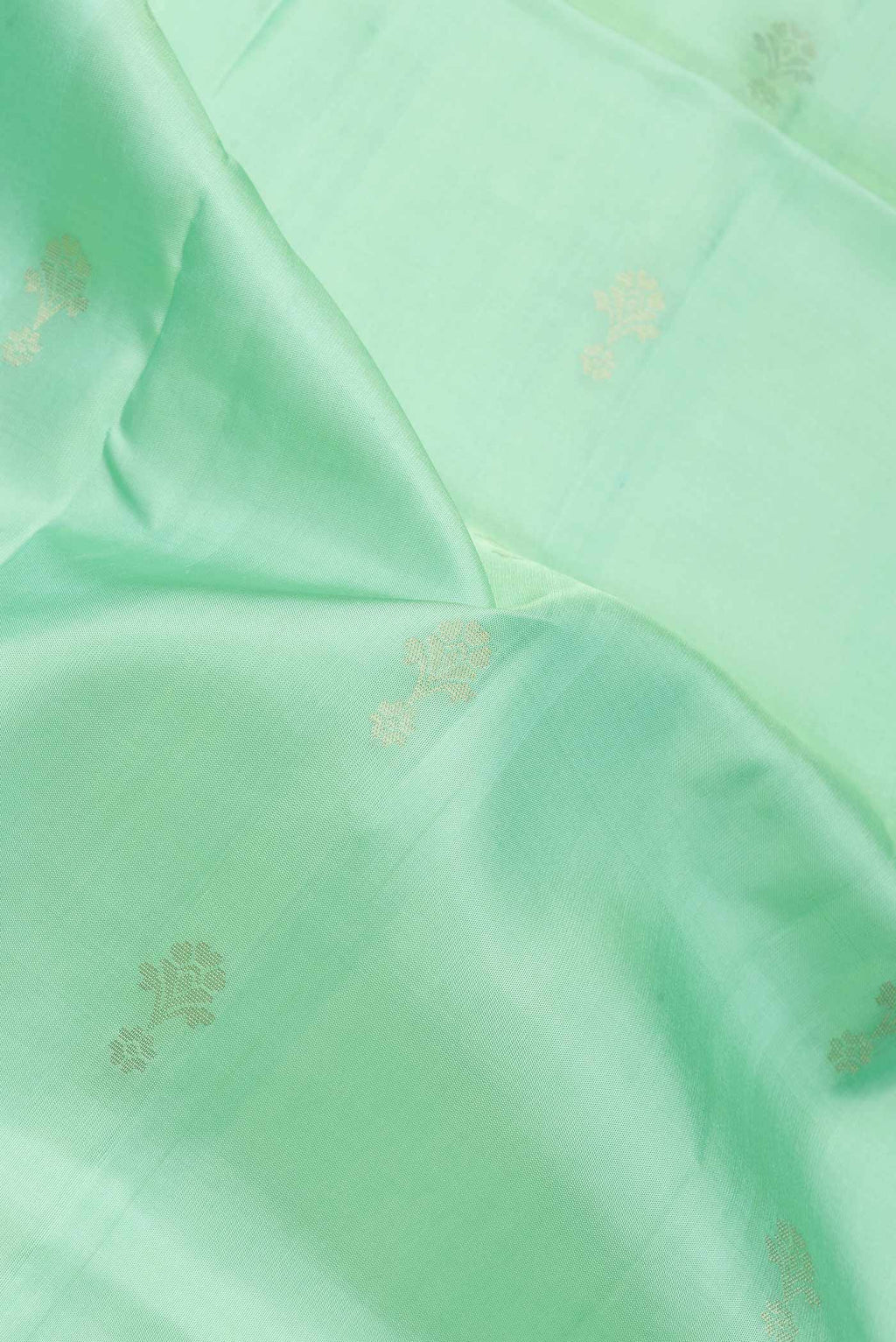 Close up of Pista Green Dual Tone Soft Silk Saree with Zari Butta on the body and Zari Border.  displaying folds