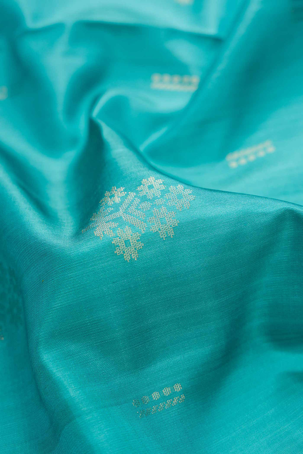 Close up of Sky Blue Dual Tone Soft Silk Saree with Zari Butta on the body and Zari Border.  displaying folds