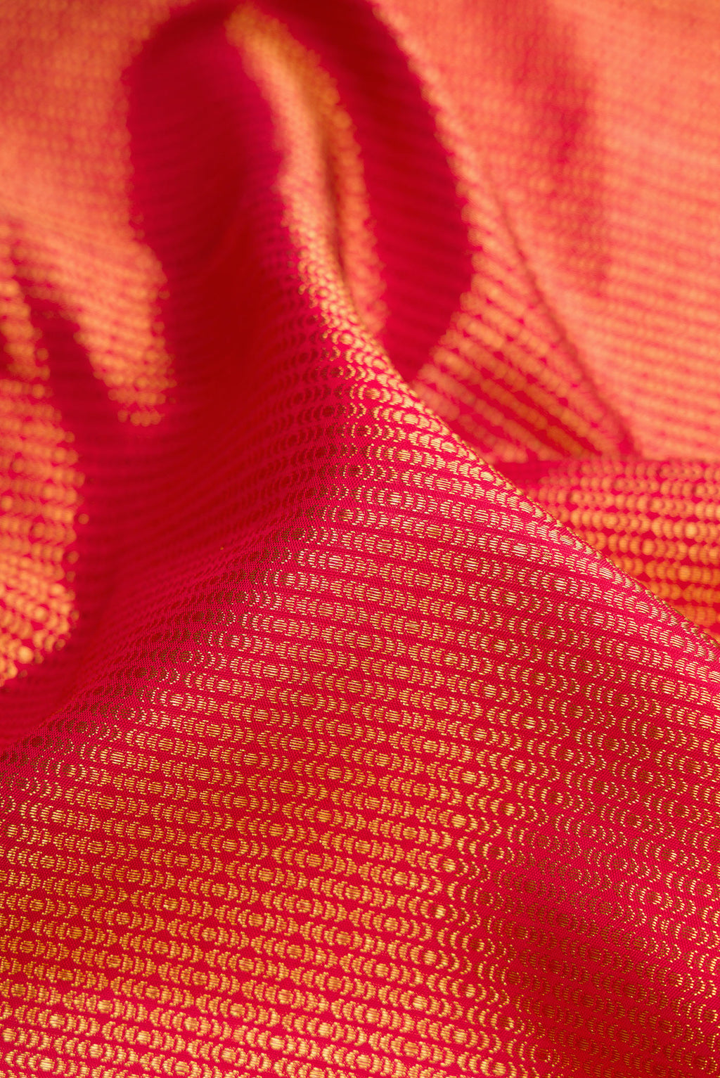 Close up of Red Dual Tone Kanchipuram Silk Saree with Zari Brocade on the body and Zari Border.  displaying folds