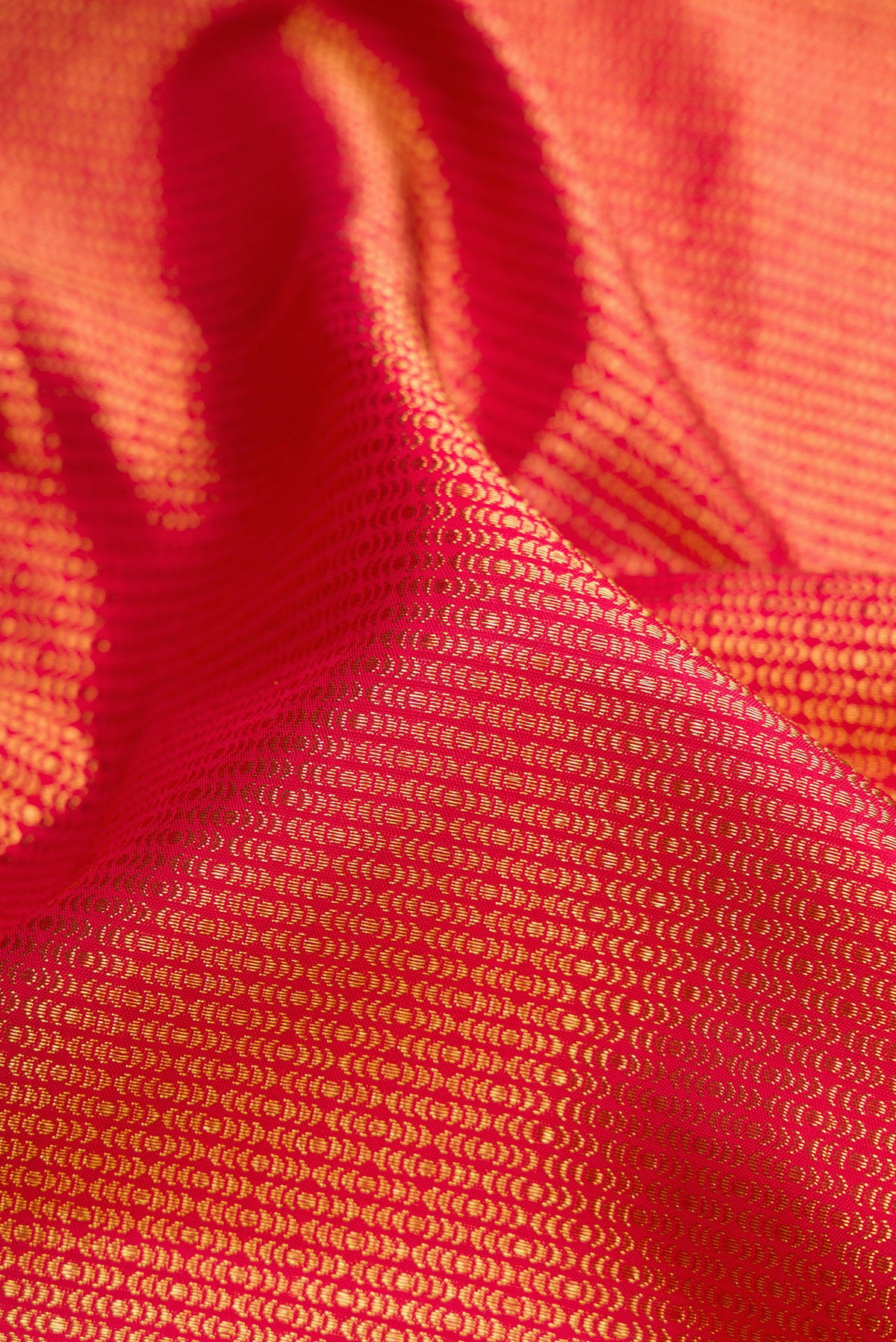 Close up of Red Dual Tone Kanchipuram Silk Saree with Zari Brocade on the body and Zari Border.  displaying folds