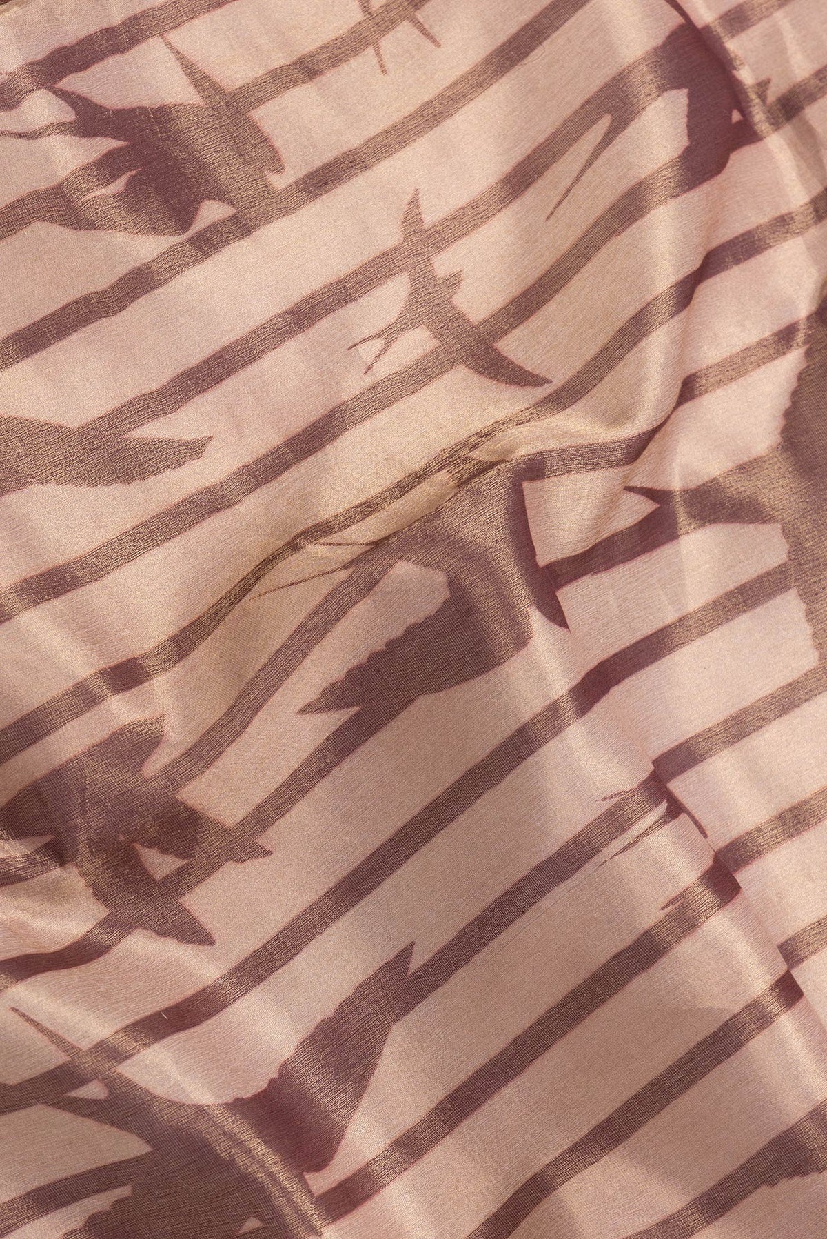 Close up of Rose Gold Dual Tone Organza Silk Saree with Zari Brocade on the body and Without Border.  displaying folds