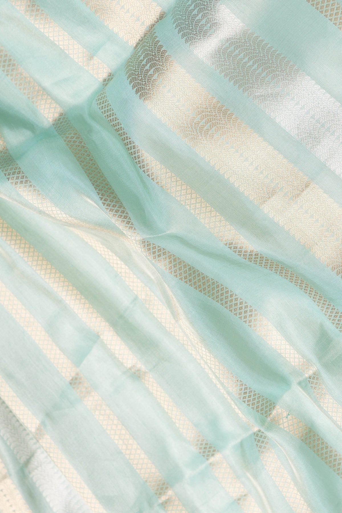 Close up of Sea Green Dual Tone Organza Silk Saree with Stripes on the body and Zari Border.  displaying folds
