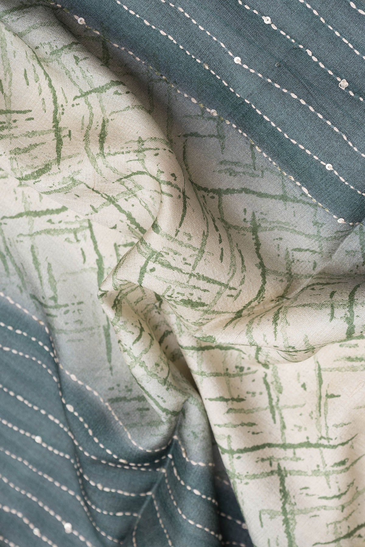 Close up of Grey Dual Tone Tussar Silk Saree with Embroidery on the body and Zari Border.  displaying folds
