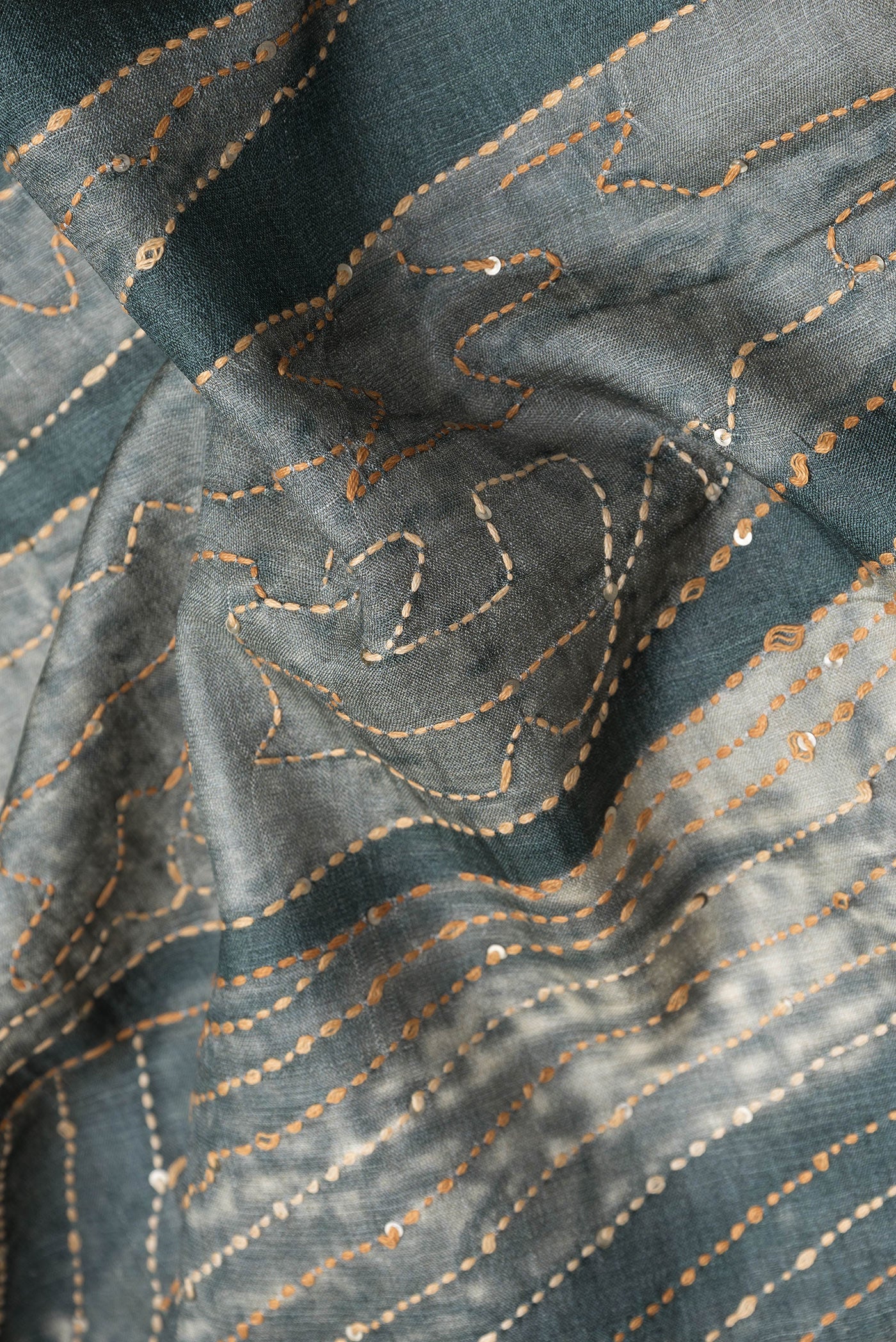 Close up of Beige Dual Tone Tussar Silk Saree with Plain Body and Embroidery Border.  displaying folds