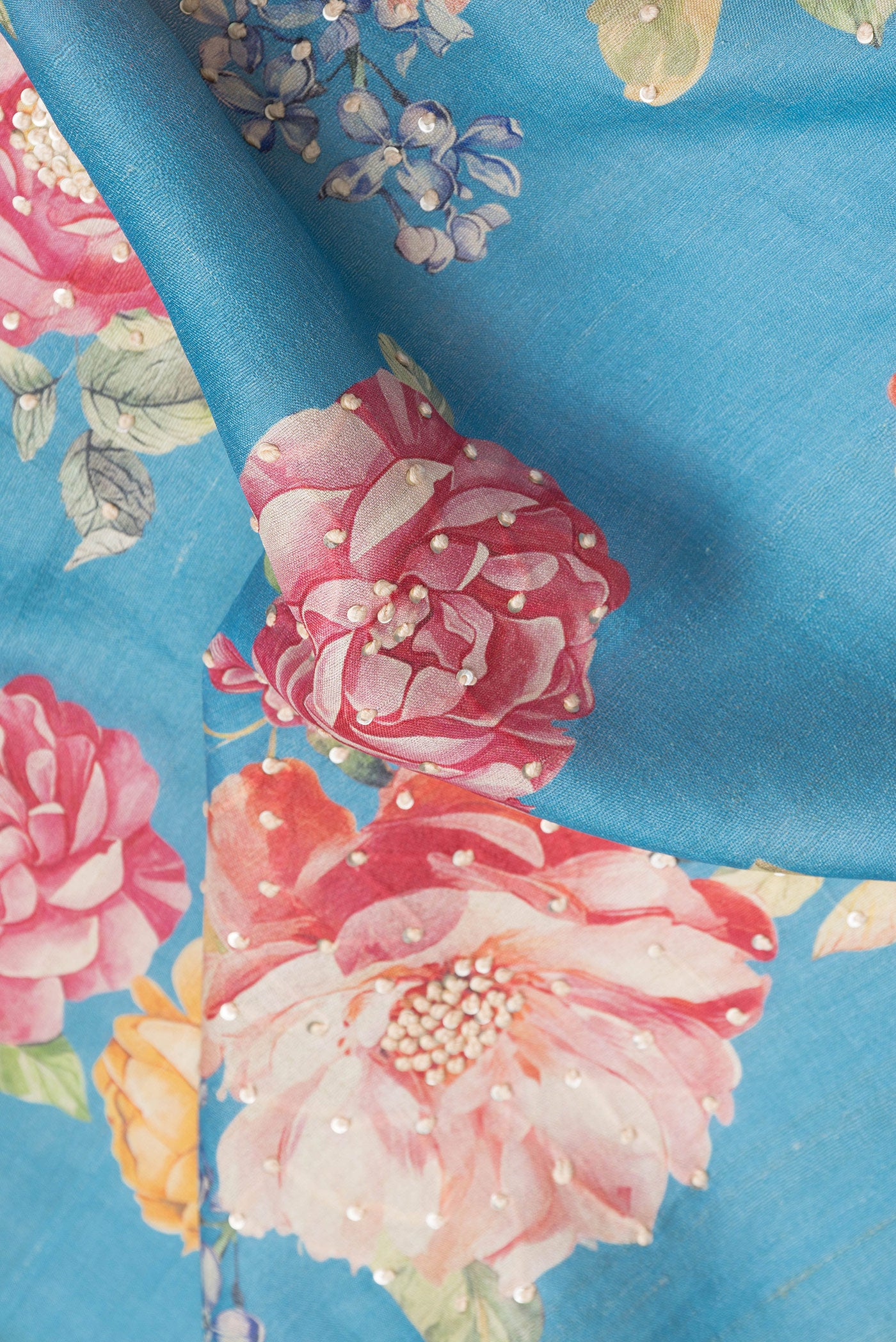 Close up of Sky Blue Dual Tone Tussar Silk Saree with Embroidery on the body and Zari Border.  displaying folds
