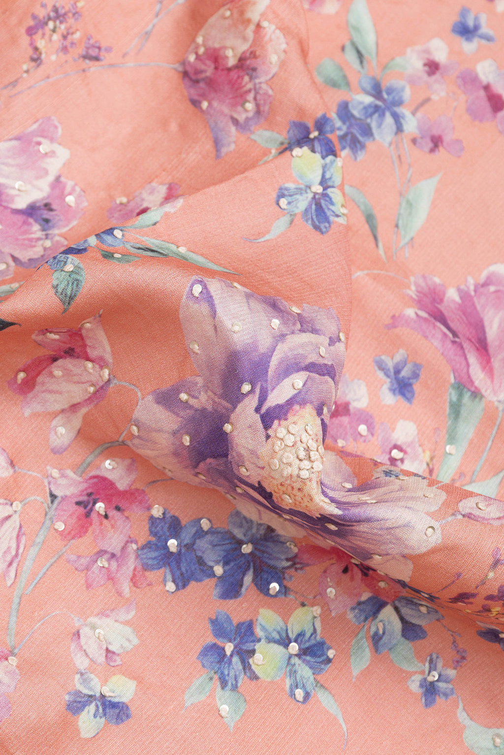 Close up of Peach Dual Tone Tussar Silk Saree with Embroidery on the body and Zari Border.  displaying folds