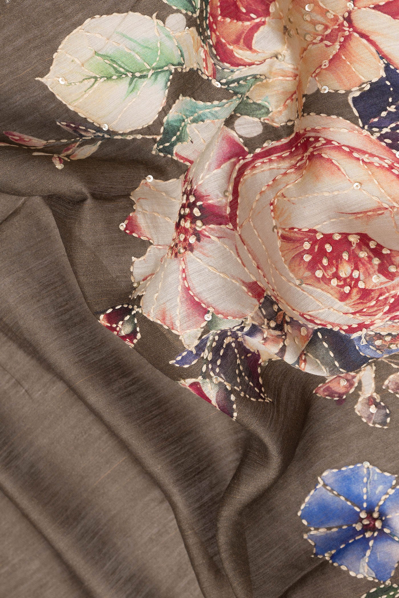 Close up of Brown Dual Tone Tussar Silk Saree with Embroidery on the body and Zari Border.  displaying folds