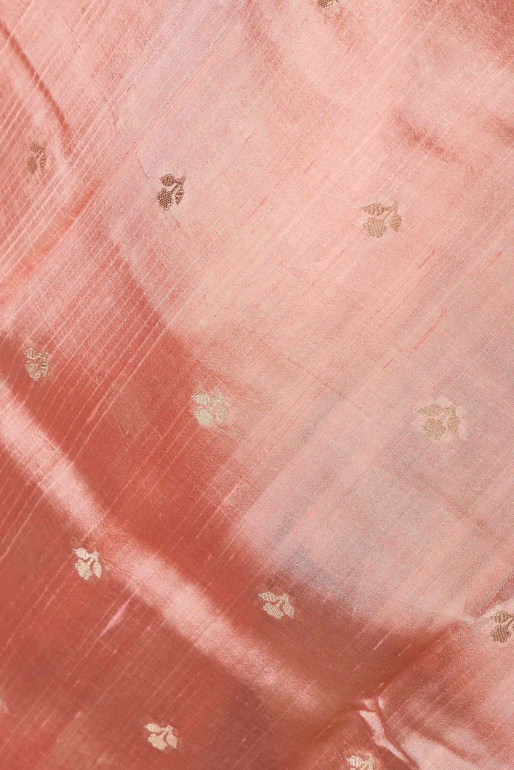 Close up of Peach Banarasi Raw Silk Saree with Zari Butta on the body and Zari And Thread Border displaying folds