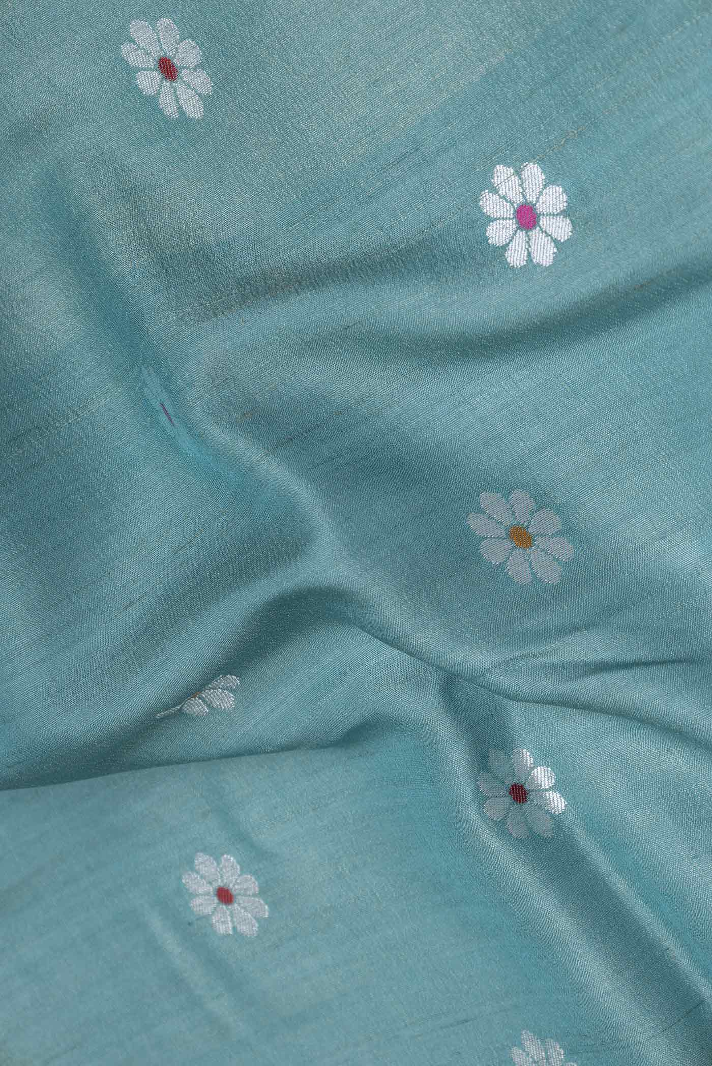 Close up of Green Dual Tone Tussar Silk Saree with Zari And Thread Butta on the body and Zari Border displaying folds