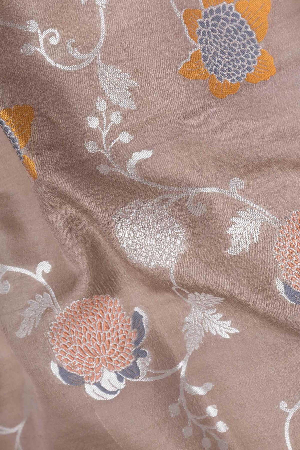 Close up of Brown Dual Tone Tussar Silk Saree with Zari Brocade on the body and Zari Border displaying folds