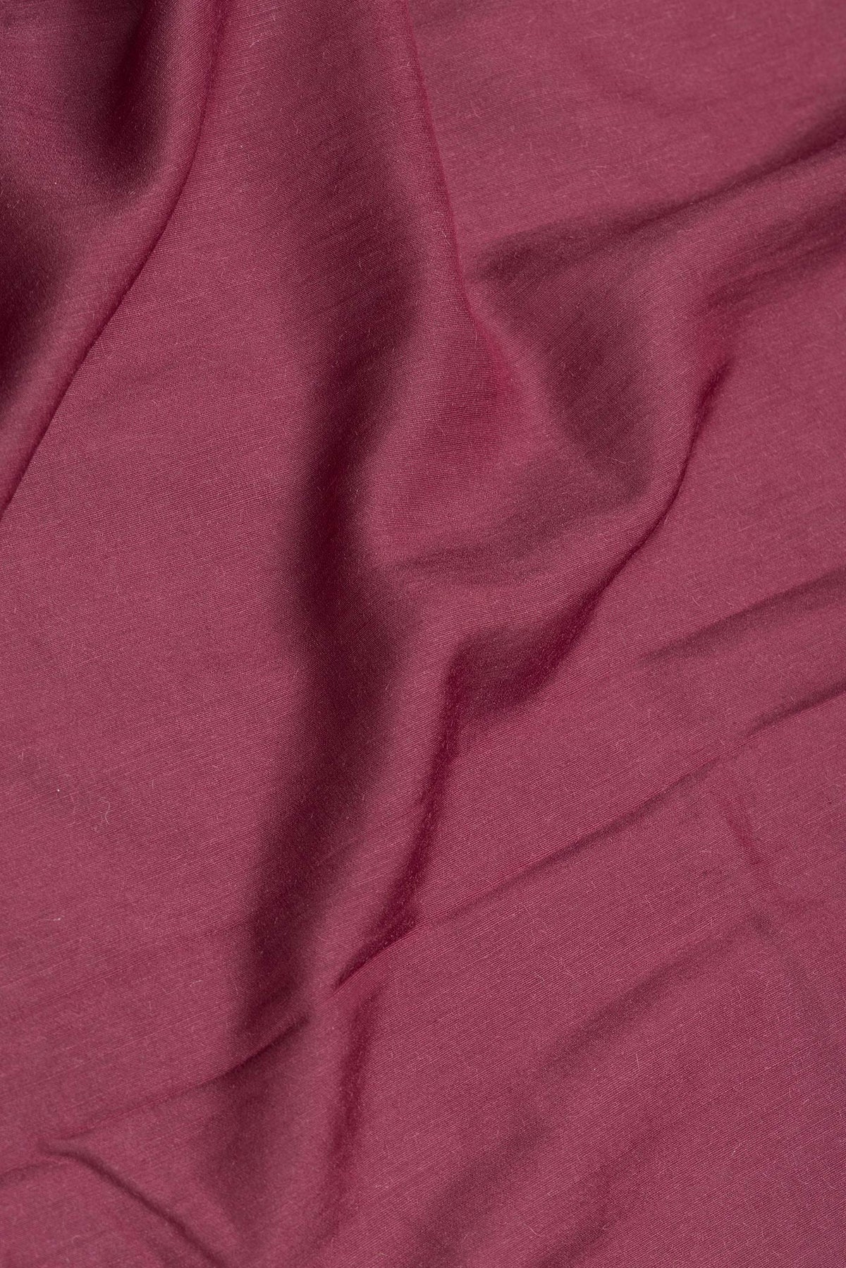 Close up of Maroon Dual Tone Tussar Silk Saree with Plain Body and Thin Zari Line.  displaying folds