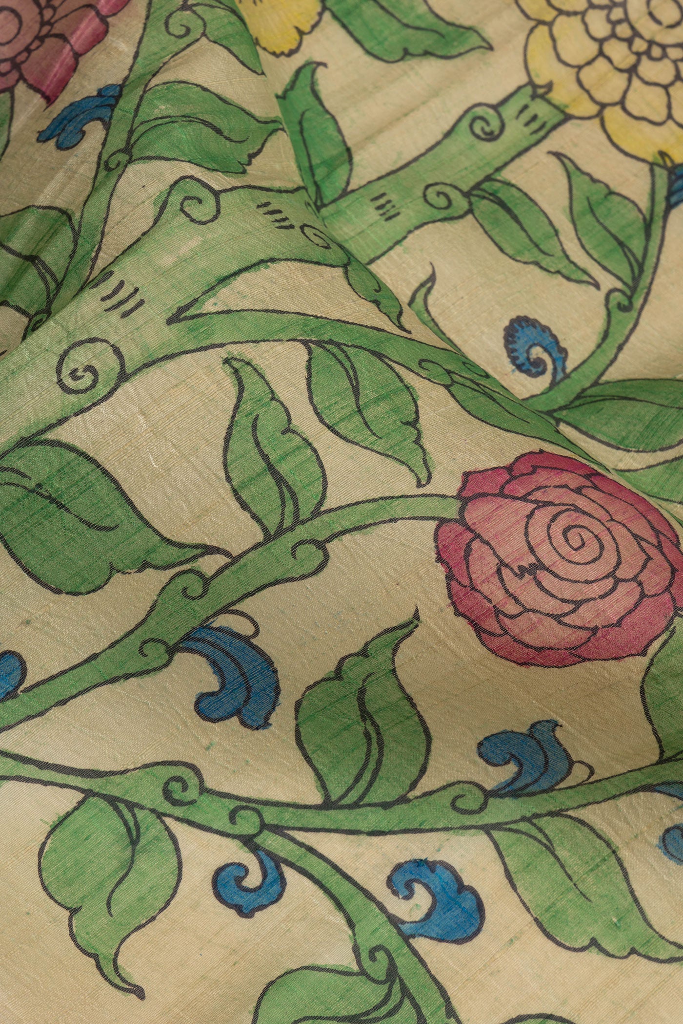 Close up of Beige Dual Tone Raw Silk Saree with kalamkari Print on the body and Zari Border.  displaying folds