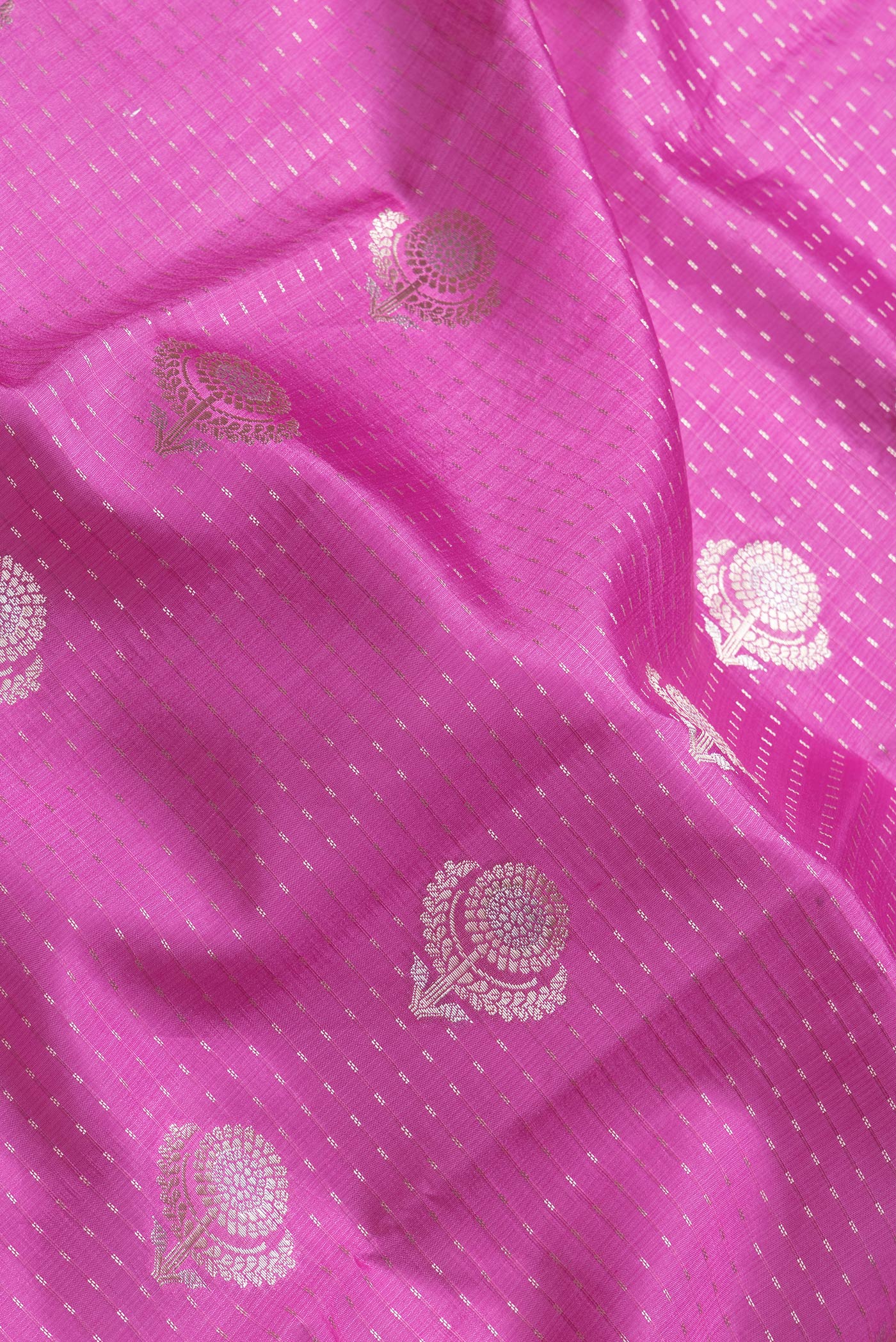 Close up of Pink Dual Tone Tussar Silk Saree with Zari Butta on the body and Zari Border.  displaying folds