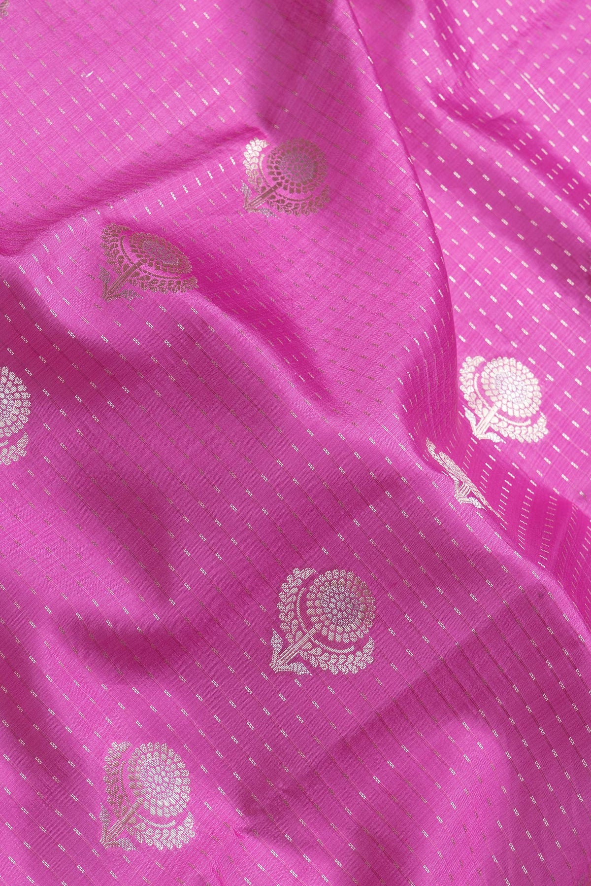Close up of Pink Dual Tone Tussar Silk Saree with Zari Butta on the body and Zari Border.  displaying folds