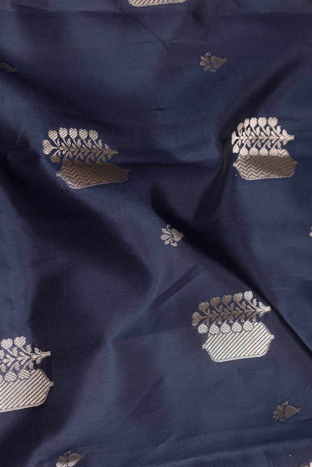 Close up of Navy Blue Banarasi Raw Silk Saree with Zari Butta on the body and Zari Border displaying folds
