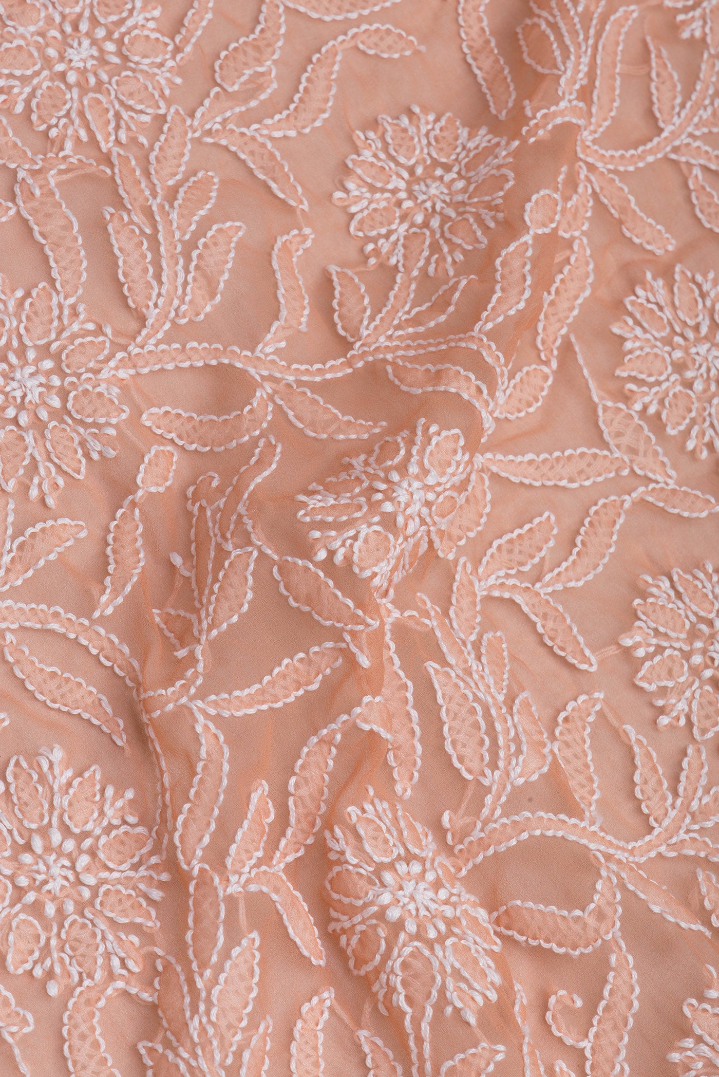 Close up of Peach Georgette Saree with Embroidery on the body and Embroidery Border.  displaying folds