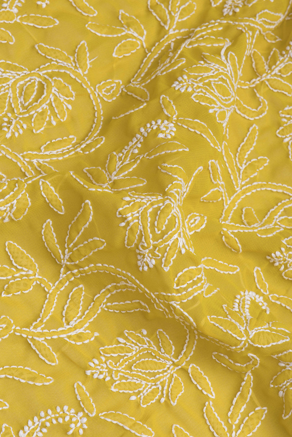 Close up of Lemon Yellow Georgette Saree with Embroidery on the body and Embroidery Border.  displaying folds