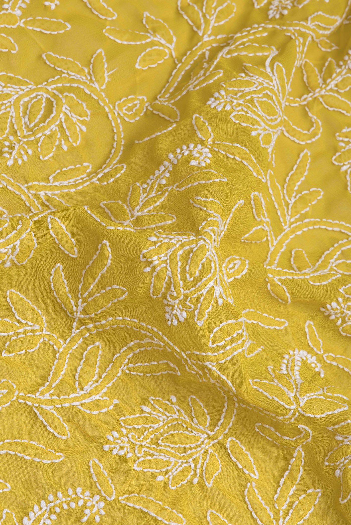 Close up of Lemon Yellow Georgette Saree with Embroidery on the body and Embroidery Border.  displaying folds