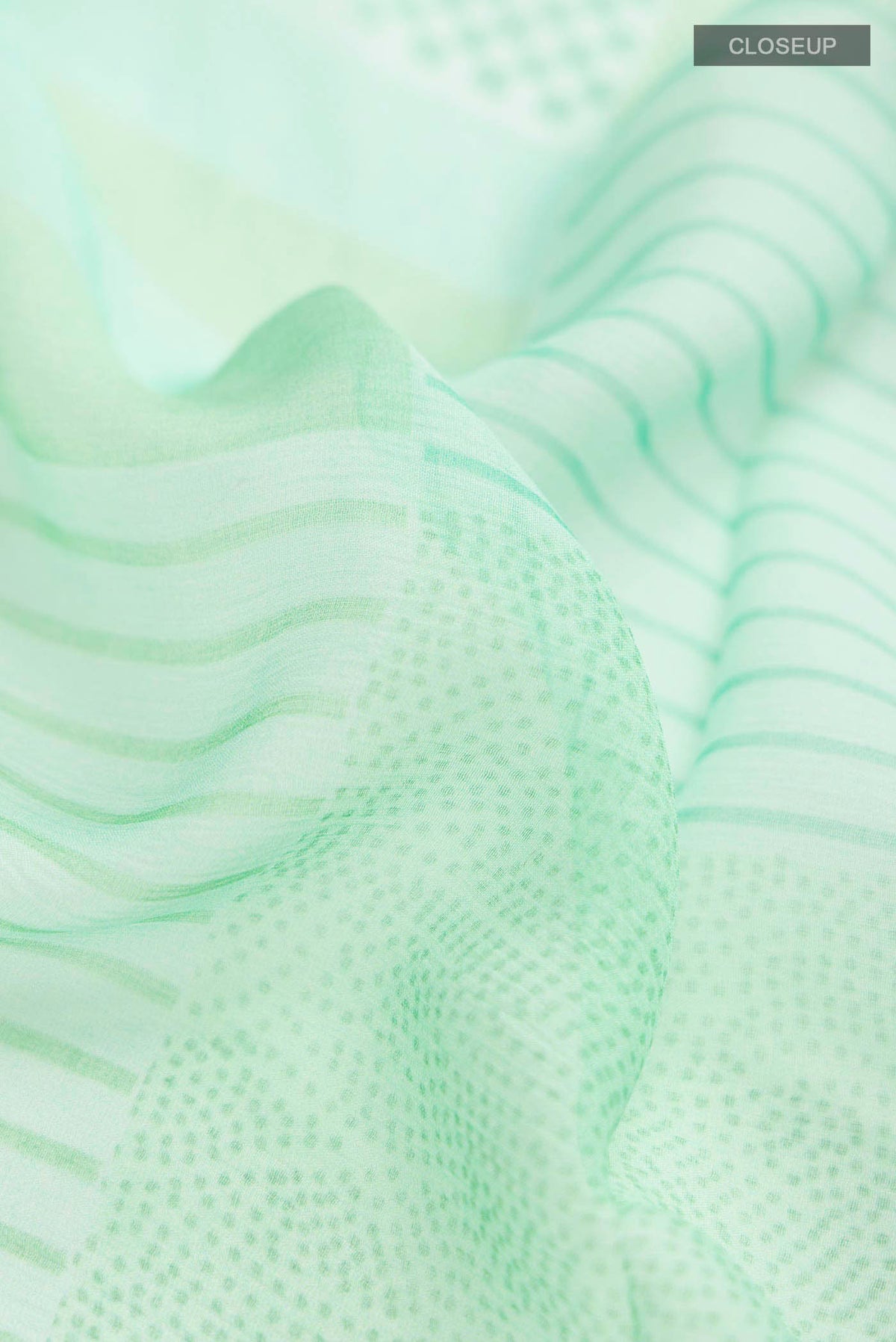 Close up of Mint Green Mysore Chiffon Saree with Printed design on the body and Plain Border displaying folds