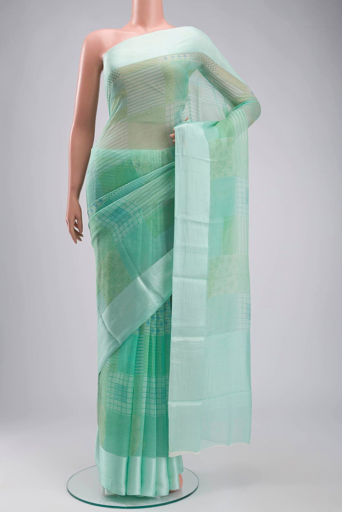 Mint Green Mysore Chiffon Saree with Printed design on the body and Plain Border displayed on a mannequin