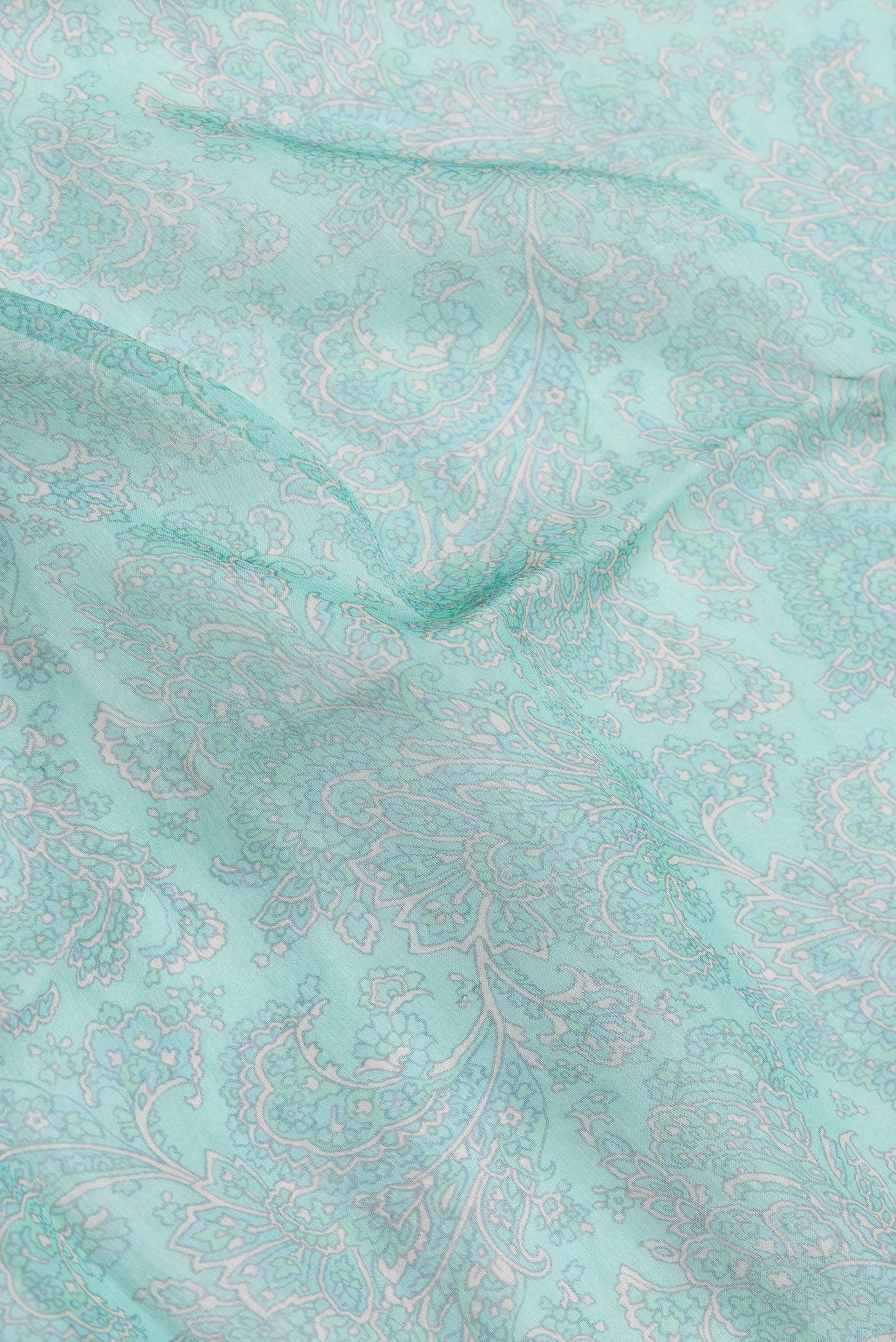 Close up of Sea Green Dual Tone Mysore Chiffon Saree with Printed design on the body and Thread Border.  displaying folds