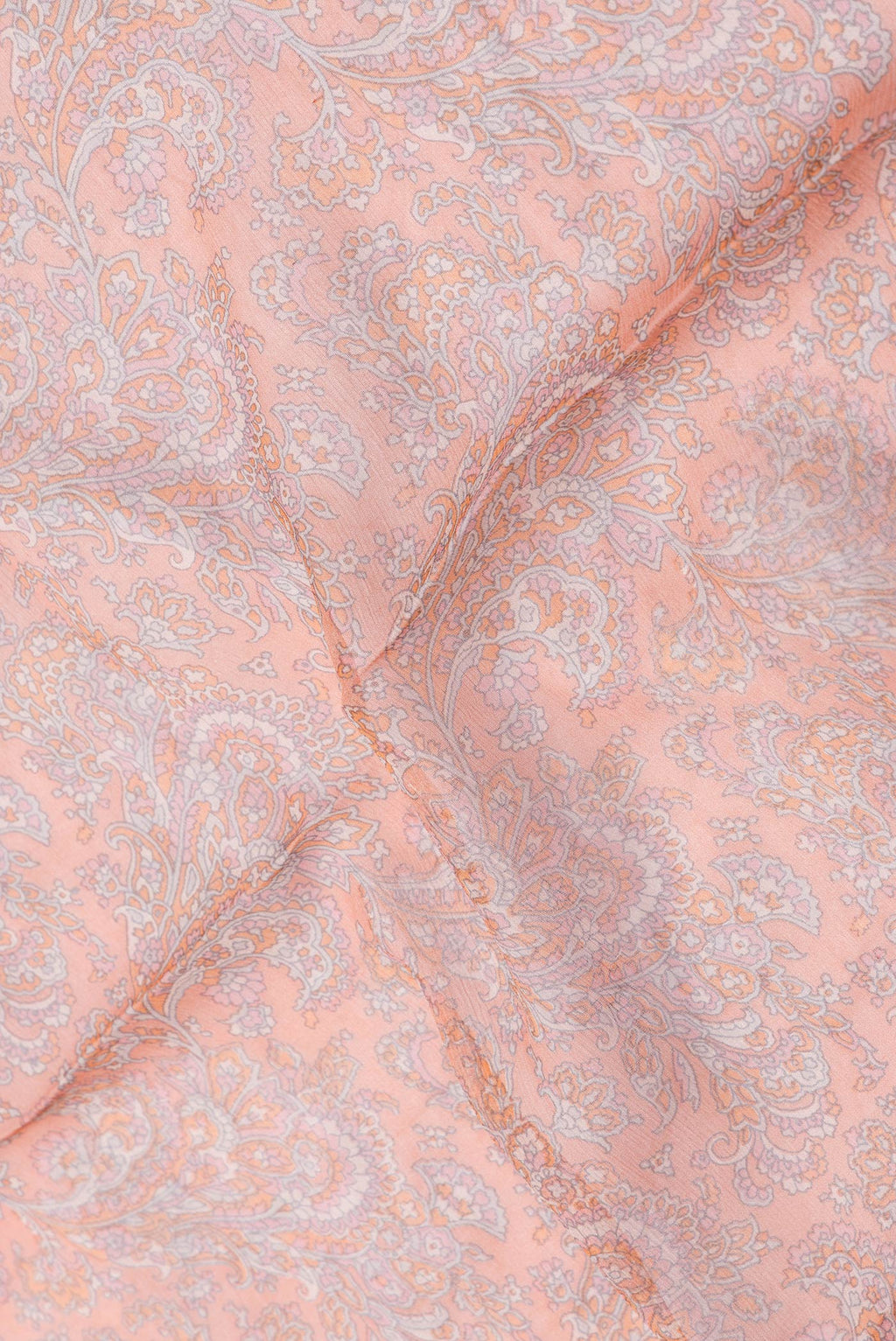 Close up of Peach Dual Tone Mysore Chiffon Saree with Printed design on the body and Thread Border.  displaying folds