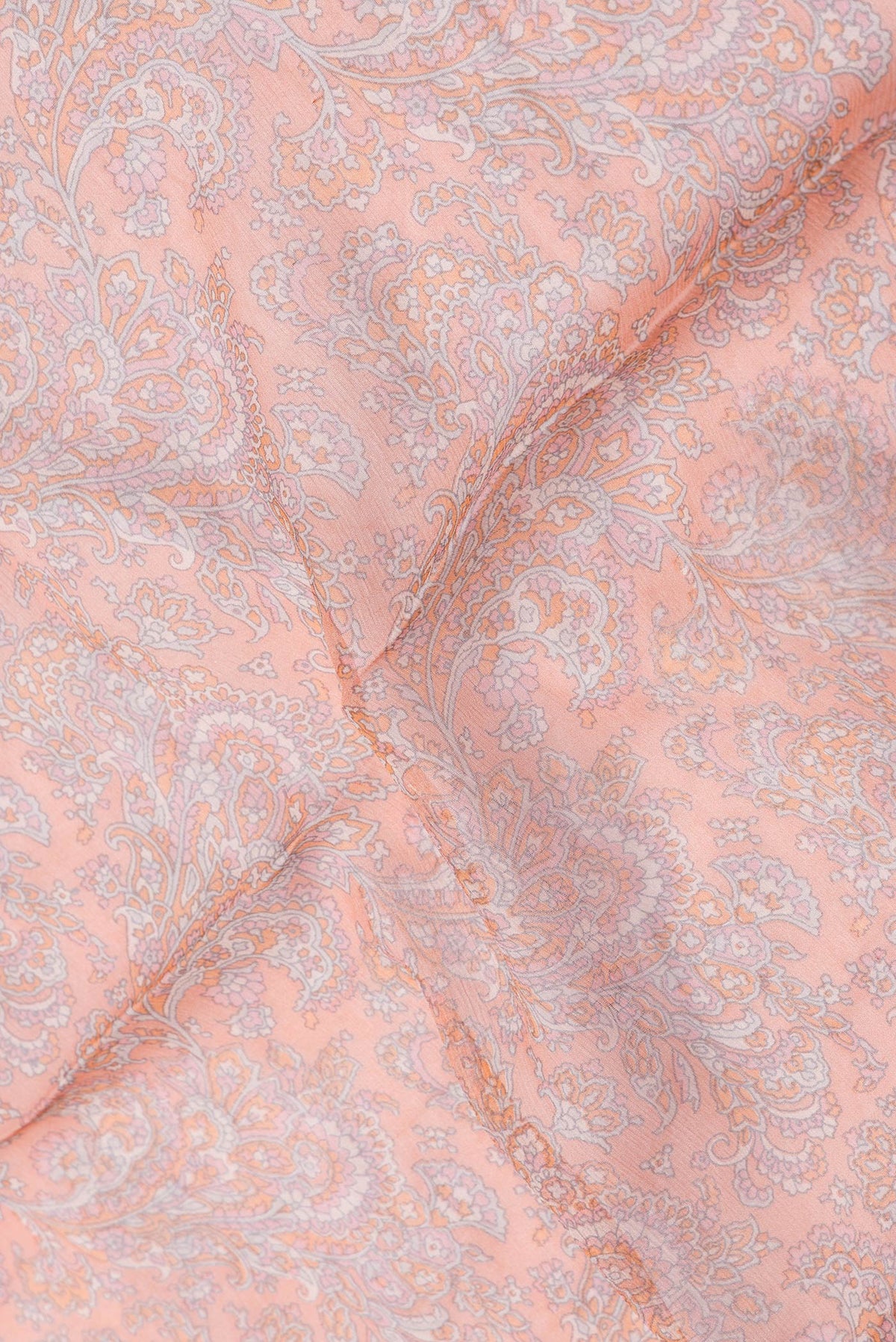 Close up of Peach Dual Tone Mysore Chiffon Saree with Printed design on the body and Thread Border.  displaying folds