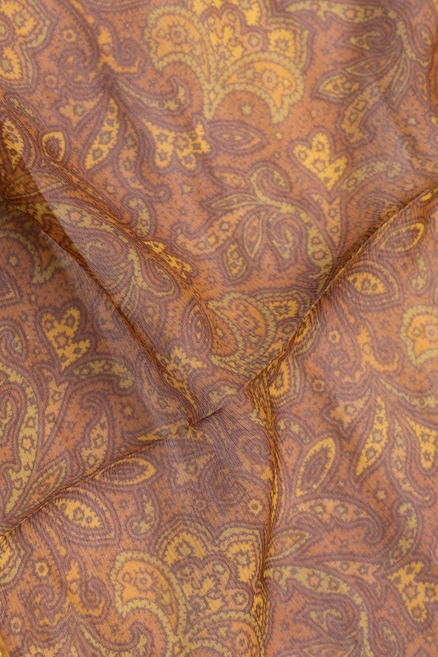 Close up of Mustard Dual Tone Mysore Georgette Saree with Printed design on the body and Zari Border.  displaying folds