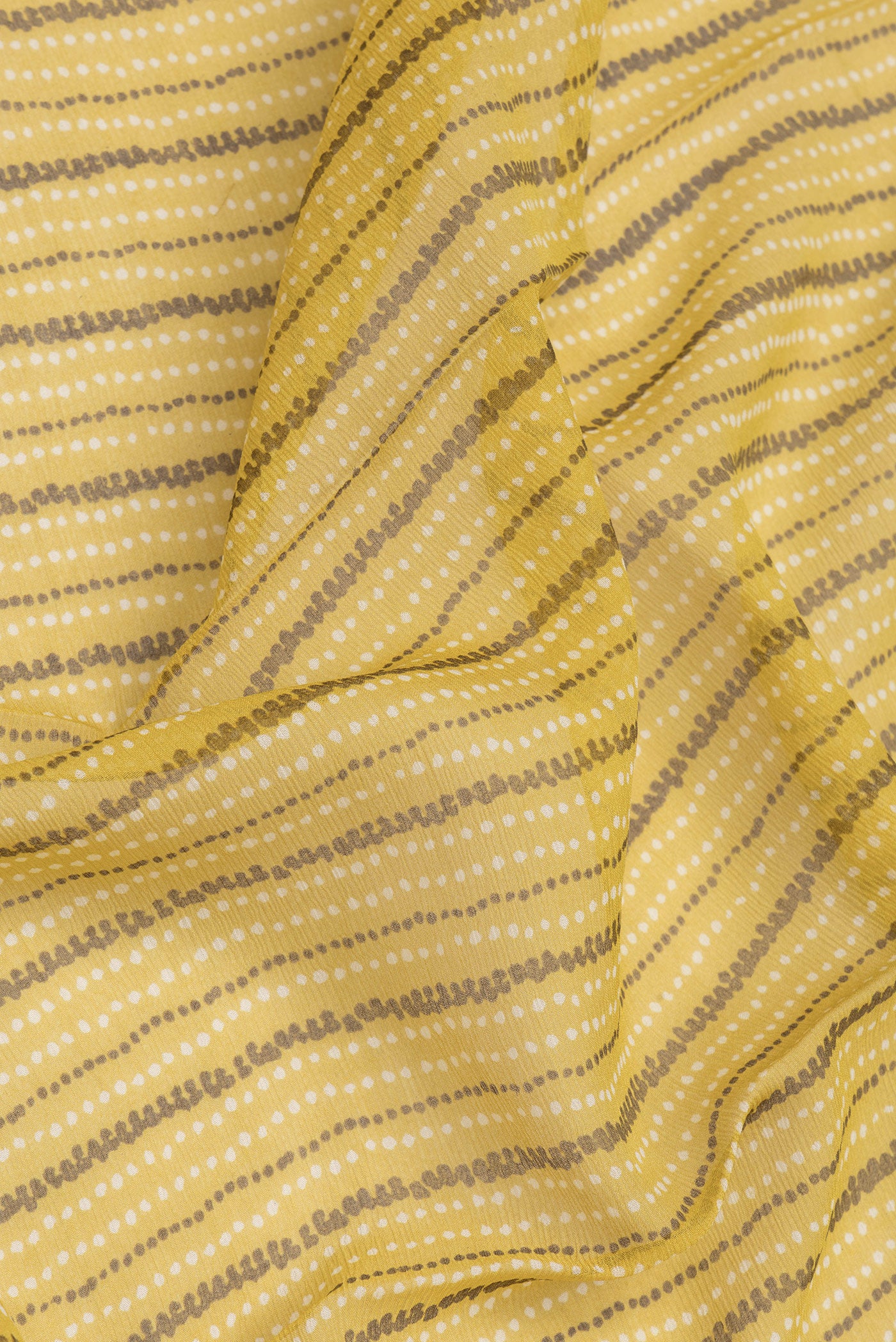 Close up of Mustard Dual Tone Mysore Chiffon Saree with Printed design on the body and Zari Border.  displaying folds