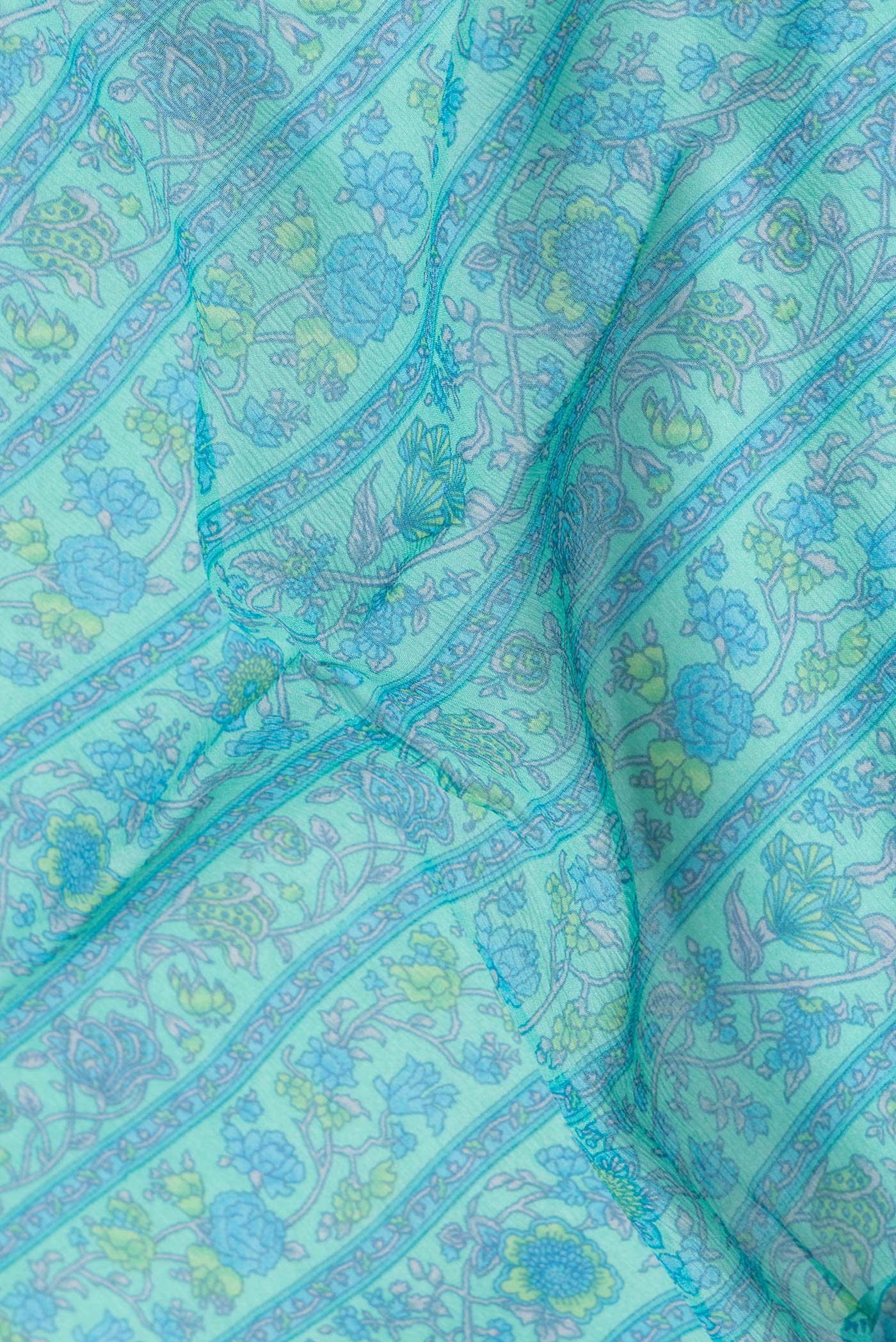 Close up of Sea Green Dual Tone Mysore Chiffon Saree with Printed design on the body and Zari Border.  displaying folds