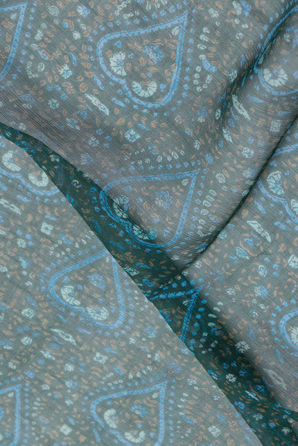Close up of Bottle Green Dual Tone Mysore Chiffon Saree with Printed design on the body and Zari Border.  displaying folds