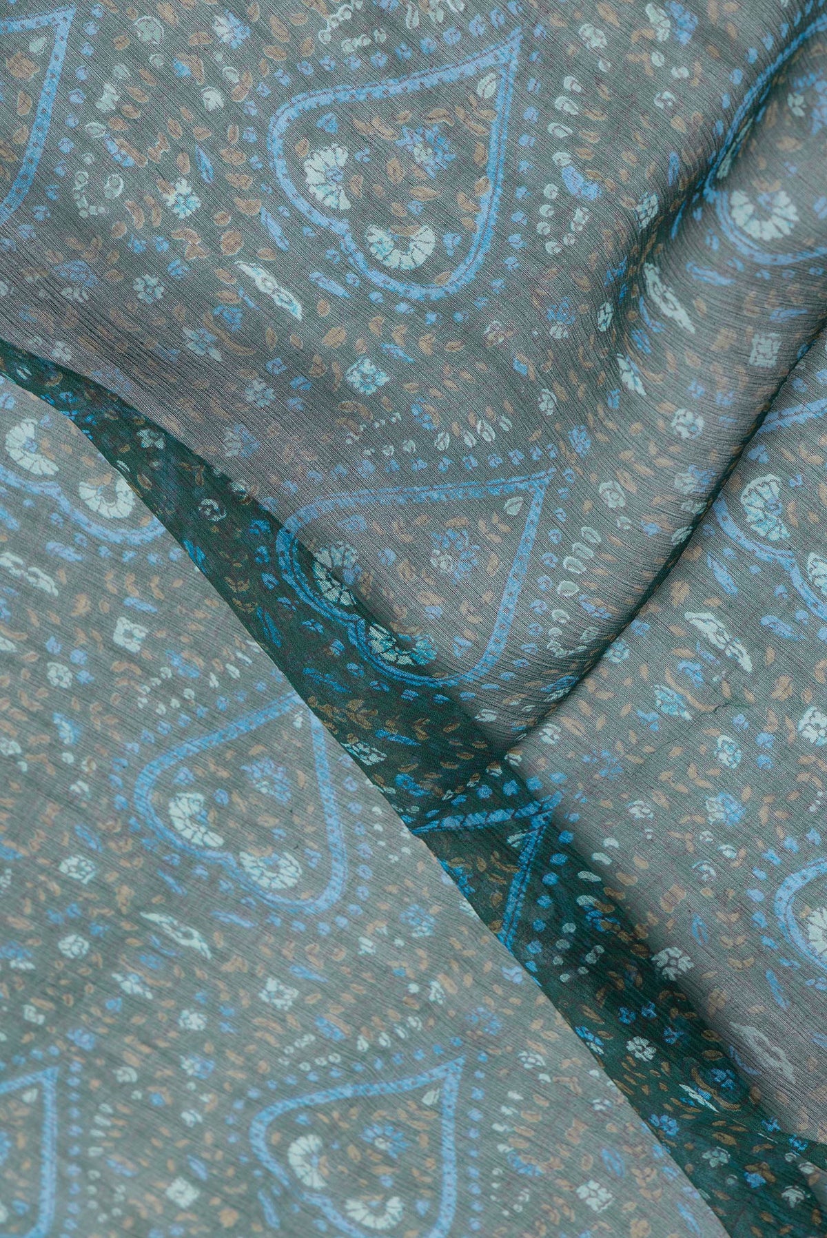 Close up of Bottle Green Dual Tone Mysore Chiffon Saree with Printed design on the body and Zari Border.  displaying folds
