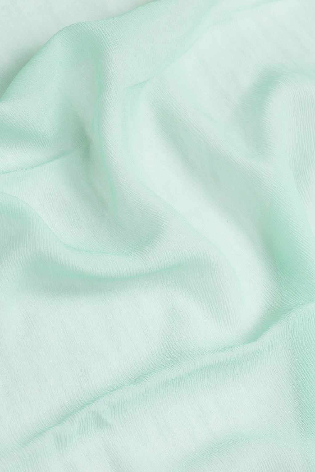 Close up of Sea Green Dual Tone Mysore Chiffon Saree with Plain Body and Thread Border.  displaying folds