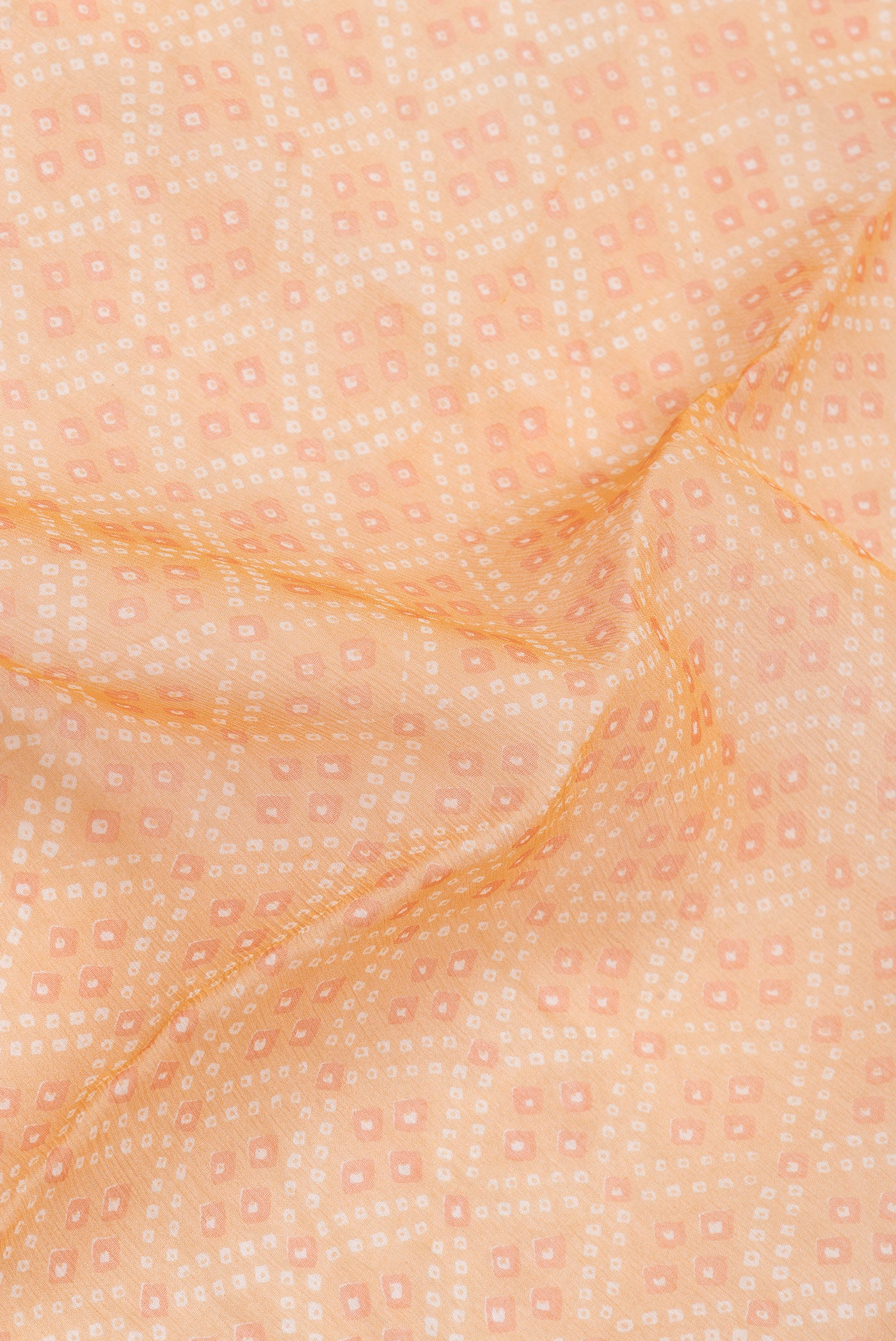 Close up of Orange Dual Tone Mysore Chiffon Saree with Printed design on the body and Zari Border.  displaying folds