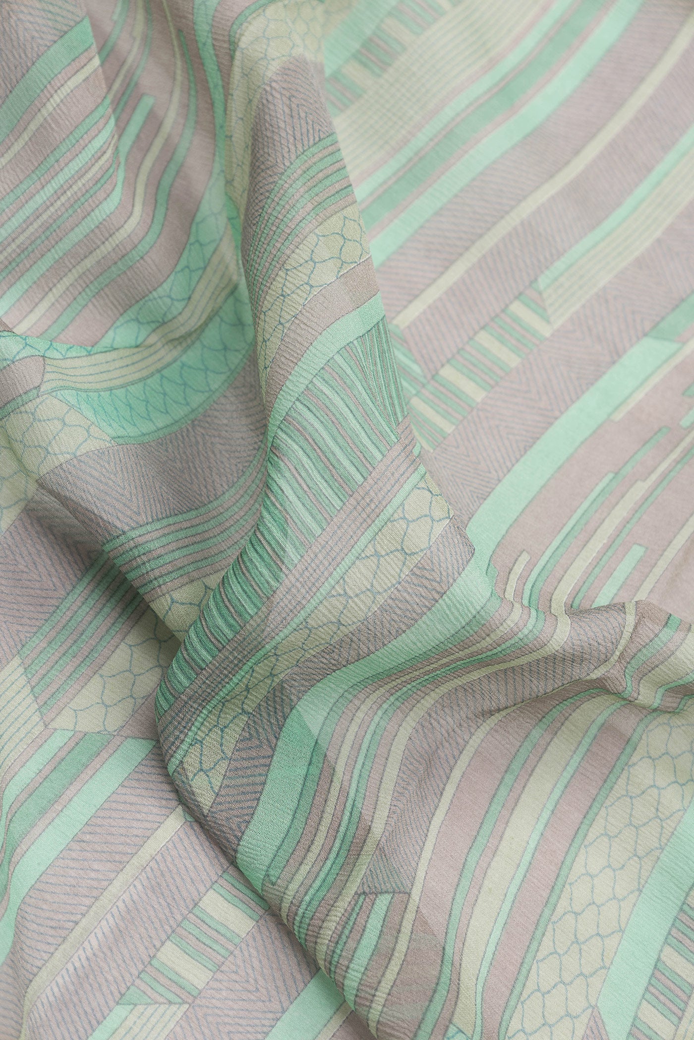 Close up of Sea Green Dual Tone Mysore Chiffon Saree with Printed design on the body and Zari Border.  displaying folds
