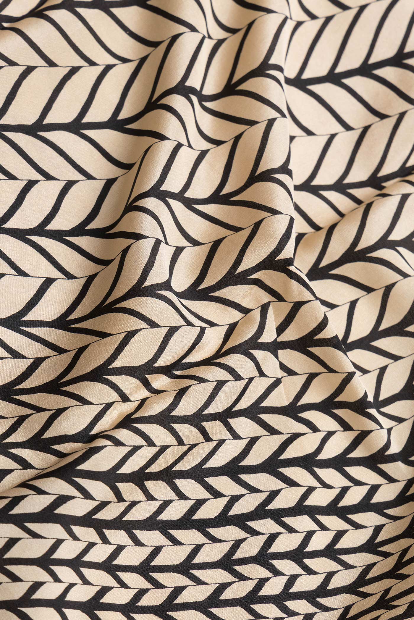 Close up of Beige Dual Tone Mysore Crepe Saree with Printed design on the body and Plain Border.  displaying folds