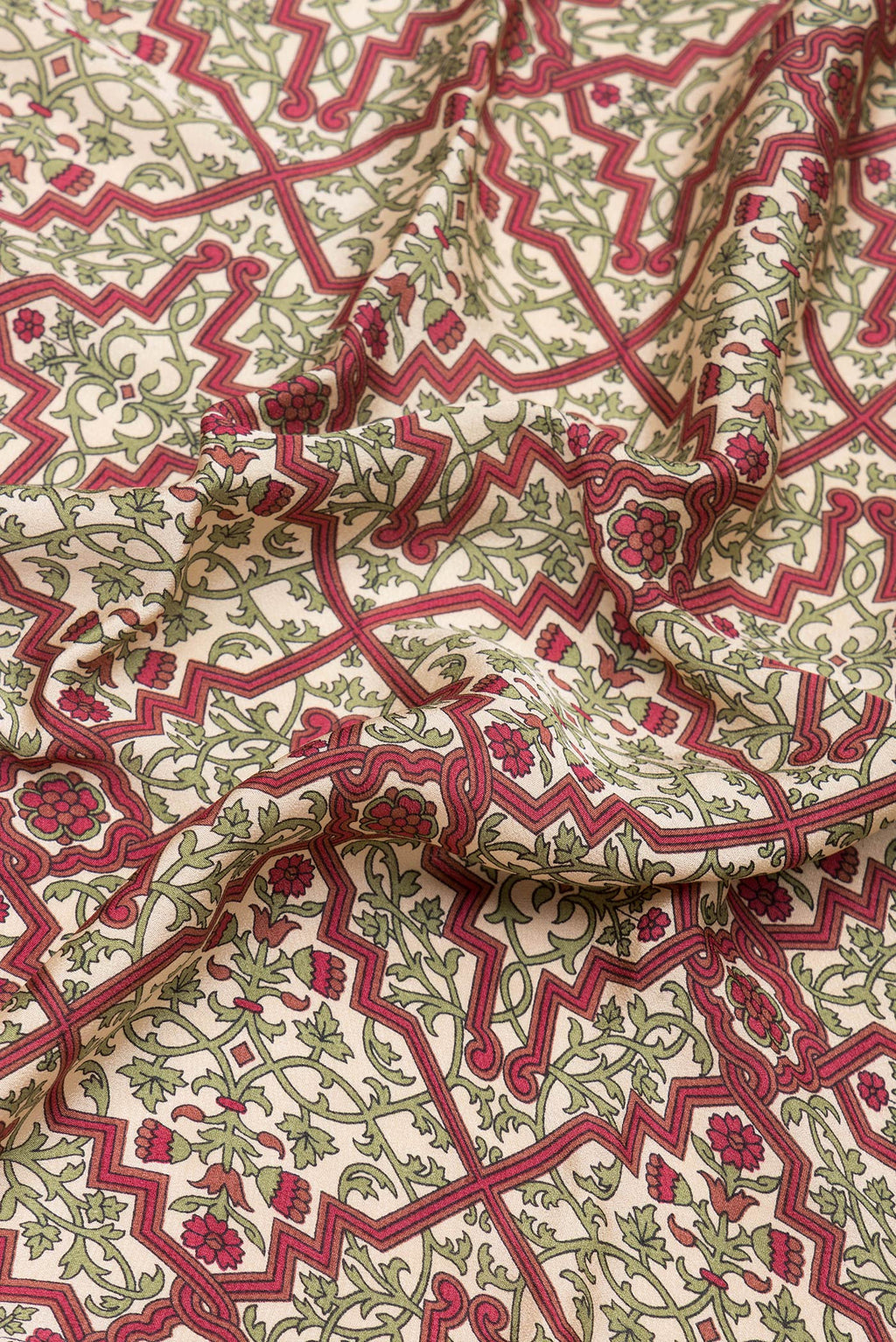 Close up of Beige Crepe Saree with Printed design on the body and Printed Border.  displaying folds